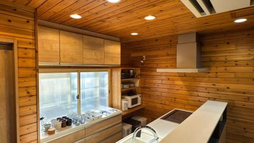 a kitchen with wooden walls and a window and a sink at Sol Stay Osaka 桜シーズン特惠 in Osaka