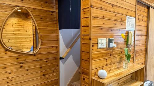a sauna with a wooden wall and a mirror at Sol Stay Osaka 桜シーズン特惠 in Osaka