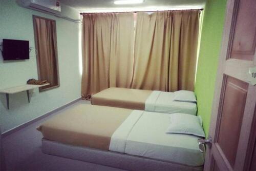 two beds in a small room with green walls at F Hotel Bayan Lepas in Bayan Lepas