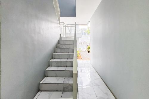 a staircase leading up to a house with white walls at Urbanview Syariah Sentul City Bogor in Cibitung