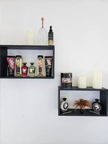 Une étagère sur un mur avec divers articles dans l'établissement Le Palais Secret 66, à Saint-Féliu-dʼAvall