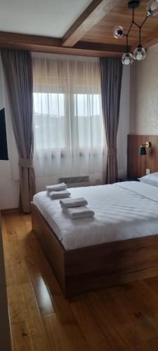 1 dormitorio con 1 cama grande con cortinas en Zlatibor apartman centar, en Zlatibor