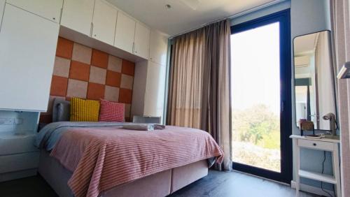 a bedroom with a bed and a large window at Suêrte cyprus in Akanthou