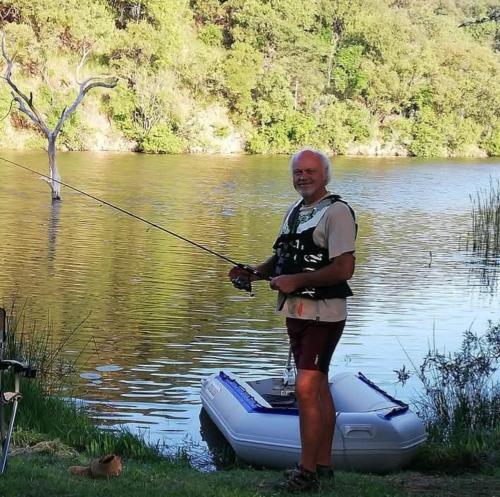 a man standing on a raft holding a fishing pole at Ebenhaeser overnight accomodation in Bela-Bela