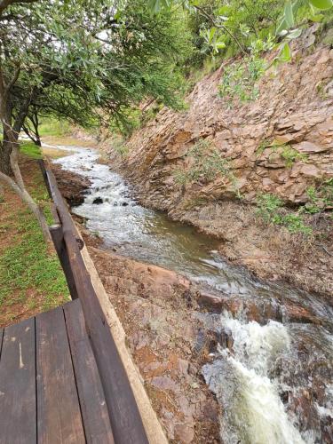 a river next to a wooden walkway next to a mountain at Ebenhaeser overnight accomodation in Bela-Bela