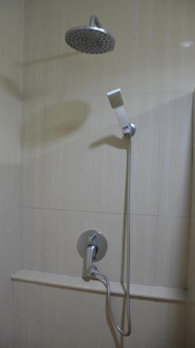 a shower with a shower head in a bathroom at Baan Manthana Hotel, Hua Hin in Hua Hin