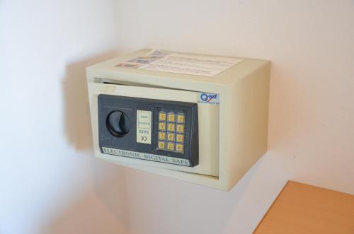 a microwave oven is attached to a wall at Baan Manthana Hotel, Hua Hin in Hua Hin