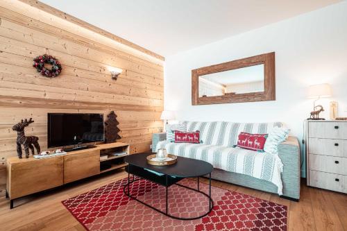 un salon avec un canapé et une télévision dans l'établissement Chamois Blanc - Ideal for families, à Megève