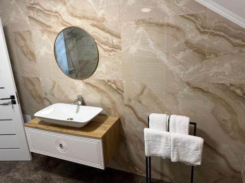 a bathroom with a sink and a mirror at Casuta de pe Ses in Novaci