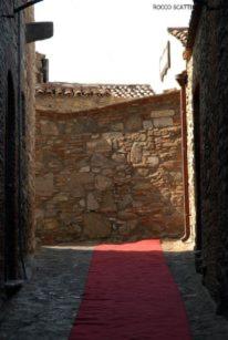 an alley with a red and blue rug on a wall at Palazzo dei Poeti in Tursi