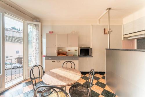 une cuisine avec une table et des chaises dans une pièce dans l'établissement Maison de ville, à Vaison-la-Romaine