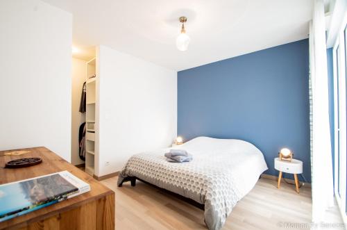 une chambre avec un lit et une table avec un ordinateur portable dans l'établissement Triplex terrasse proche métro - Ty ar Mabilay, à Rennes