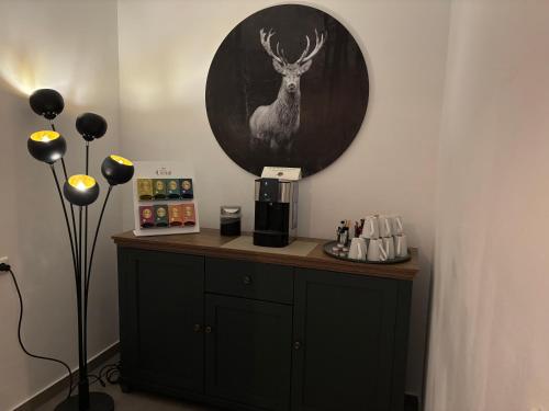 a room with a counter with a picture of a deer on the wall at Hotel Am Schwarzen Berg in Stade