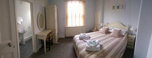 1 dormitorio con 1 cama con 2 toallas en Knights Rest en Shanklin