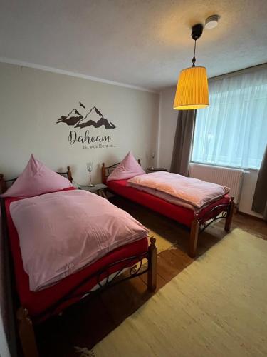 a bedroom with two beds and a sign on the wall at Behagliches Haus mit Kamin Bayerischer Wald in Tiefenbach