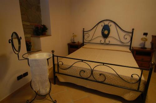 a bedroom with a bed with a wrought iron frame at Palazzo dei Poeti in Tursi
