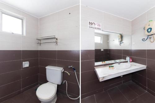a bathroom with a toilet and a sink and a mirror at OYO 90118 Suntex Hotel in Kampong Baharu Cheras Batu Sembilan