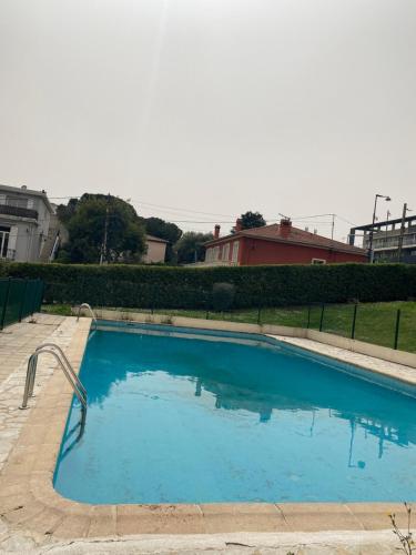 une grande piscine bleue dans une cour dans l'établissement Dernier étage vue mer avec parking et piscine, à Antibes