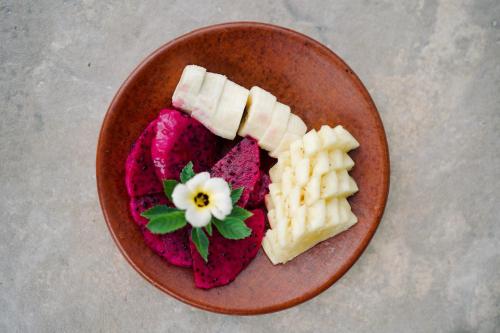 a plate of food with fruit and waffles on it at Abian Bali Resort Amed in Amed
