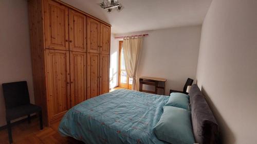 a bedroom with a bed and a chair and a window at LinHaus in Limone Piemonte