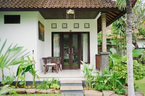 a house with a front door with a table and chairs at Abian Bali Resort Amed in Amed