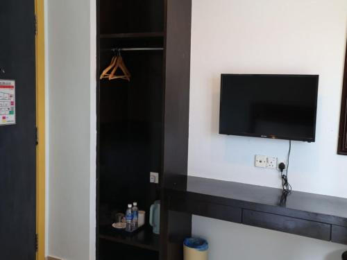 a room with a tv on a white wall with at Hotel O D Nice Inn Hotel in Kuala Lumpur