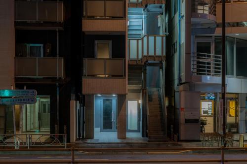 a street sign in front of a tall building at Mi-Kan Design Hotel in Tokyo