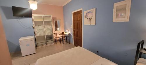 a room with a bed and a refrigerator and a table at center apartments in Lefkada Town
