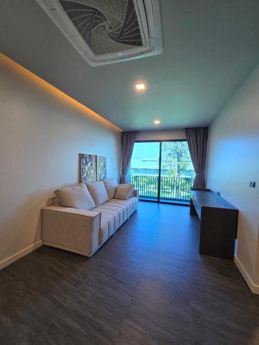 a living room with a couch and a large window at Live Specialty House in Ban Wang Pong