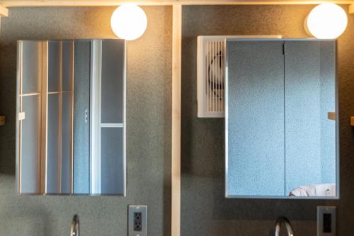a kitchen with two mirrors and a sink and a cabinet at Mi-Kan Design Hotel in Tokyo