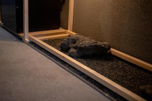 a teddy bear laying on the ground in front of a door at Mi-Kan Design Hotel in Tokyo