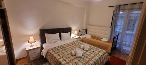 a bedroom with a bed and two lamps and a window at center apartments in Lefkada Town