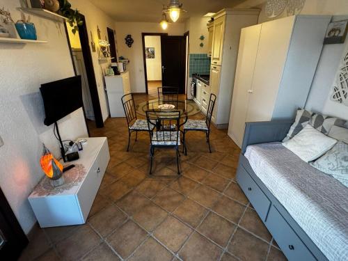 Habitación pequeña con mesa, cama y dormitorio en Sardegna Porto San Paolo, en Porto San Paolo