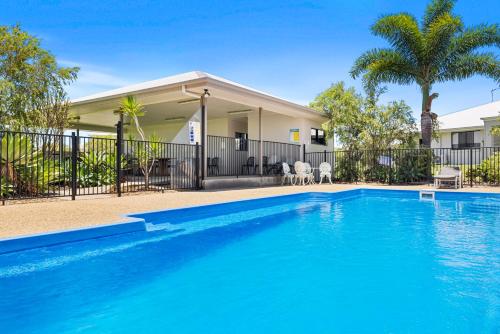 a swimming pool in front of a house at Casa Nostra Motel in Rockhampton