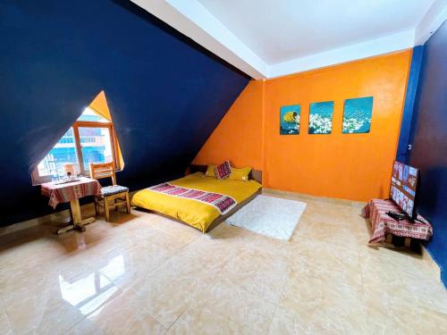 a bedroom with a bed and a blue and orange wall at Bamboo Home in Sa Pa