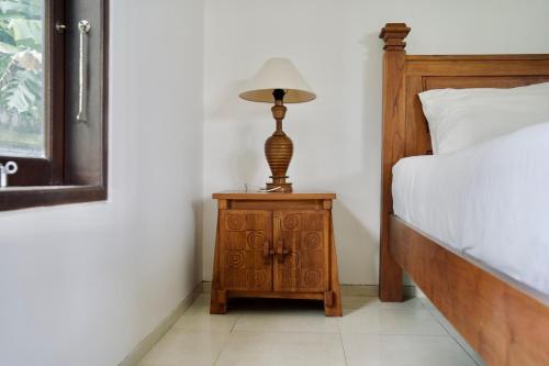 a lamp on a night stand next to a bed at Abian Bali Resort Amed in Amed