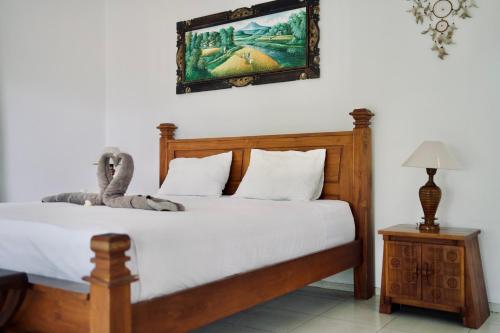a bedroom with a bed and a picture on the wall at Abian Bali Resort Amed in Amed