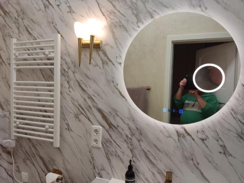 a person taking a picture of a mirror in a bathroom at BellaCaro in Löhne