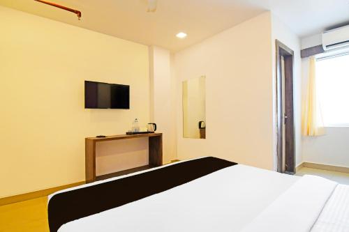 a bedroom with a bed and a tv on the wall at Townhouse Mancheswar Bhubaneswar Formerly Kamla Inn in Bhubaneshwar