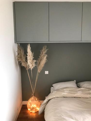 - une chambre avec un lit et un vase avec des plumes dans l'établissement L'Isernon, appartement avec balcons et garage, à Annecy
