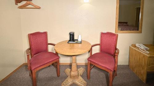 a room with a table and two chairs and a mirror at Young's Motel in Tok