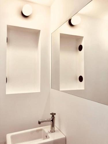 une salle de bain avec un lavabo et un miroir dans l'établissement Le Poulailler, private house with garden and parking, à Aix-en-Provence