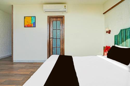 a bedroom with a white bed and a window at Collection O Arvind Marg Pachamarhi in Pachmarhī