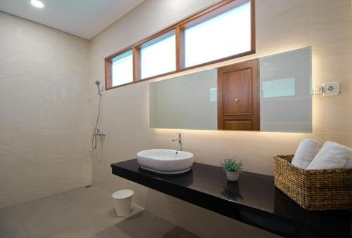 a bathroom with a sink and a mirror at Family Only Villa Private Pool with City View - De Reiz Ara Syariah 4BR in Ciburial