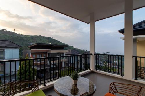 a balcony with a table and chairs and a view at Family Only Villa Private Pool with City View - De Reiz Ara Syariah 4BR in Ciburial