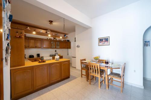 a kitchen and dining room with a table and chairs at Maria's Home Aegina in Kondós