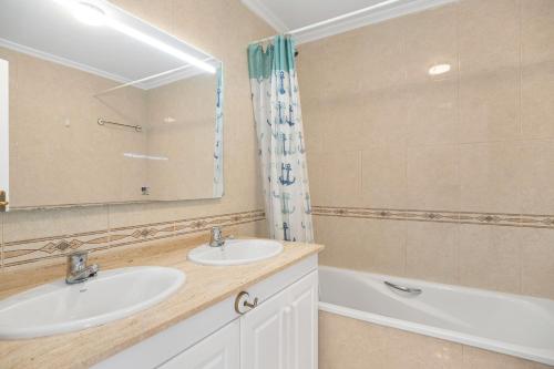 a bathroom with two sinks and a mirror and a tub at Casa Del Alba Golf in Alicante