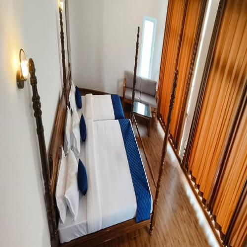 a bedroom with a bed with blue and white sheets at COASTAL GRAND RESORT - KOTAGIRI in Kotagiri