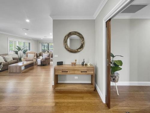 a living room with a table and a mirror at The Nest by Batemans Bay in Batemans Bay
