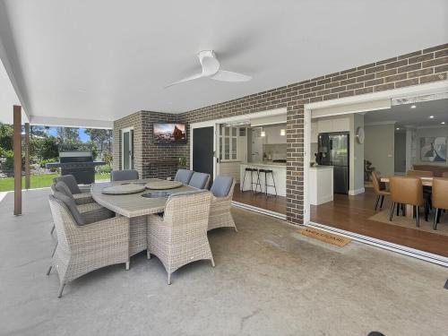a living room with a table and chairs and a kitchen at The Nest by Batemans Bay in Batemans Bay